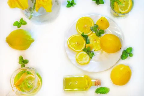 Flat lay of lemon fruit, mint leaves and sprigs and lemon drink in a jug and  Stock Photos