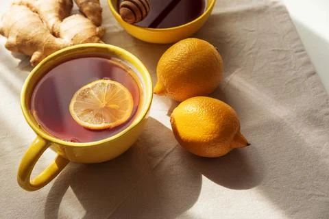 Flat Lay with Lemon Tea, Ginger and Honey on Light Table under Sun Light Stock Photos