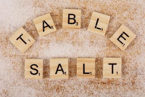 Flat Lay of Letters spelling Table Salt on wooded background Photos
