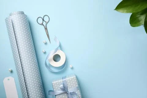 Flat lay of light blue polka dot gift wrapping paper, a wrapped box, ribbon,  스톡 사진
