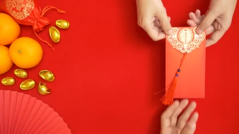 Flat lay looping footage of hand giving red envelope for Chinese Lunar New Year Stock Footage 262956160