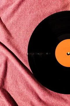 Flat lay of LP vinyl record on a pink fabric cloth background.  Old vintage r Foto stock