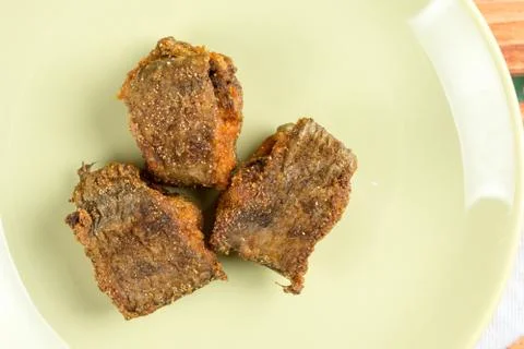 Flat lay macro closeup above green plate with fried hake fish Stock Photos