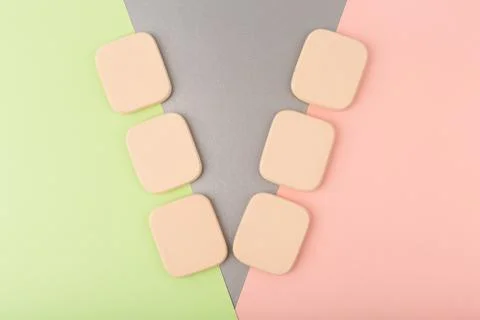 Flat lay with make up sponges against multicolored colored background. Concept Stock Photos
