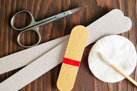 Flat lay with manicure equip, scissors and nail file on the rough wooden table Stock Photos