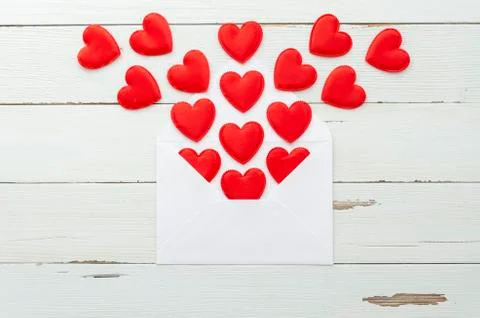 Flat lay many red hearts carved in felt collected in envelope on white Stock Photos