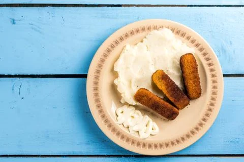 Flat lay mashed potatoes served with fish meat sticks on the plate Stock Photos