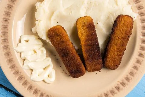 Flat lay mashed potatoes served with fish meat sticks on the plate Stock Photos