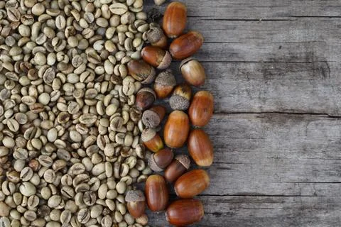 Flat lay  of   middle roasted  coffee beans and acorn on wooden  as backgroun Stock Photos