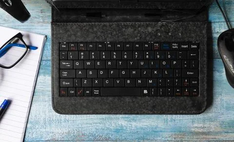 Flat lay of mini computer or laptop along with notebook, spectacles, pen, cof Stock Photos