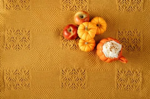 Flat Lay of mini pumpkins, apples and pumpkin mug on yellow blanket. Stock Photos