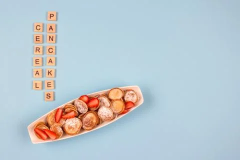 Flat lay minimal composition with mini pancakes cereal with strawberries on Stock Photos