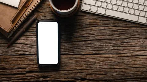 Flat lay mobile phone, computer, coffee cup and stationery on table. Stock Photos