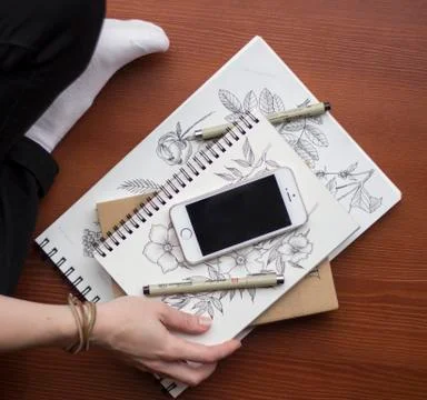 Flat lay with mobile phone, pen, sketchbooks on modern workplace. Top view Stock Photos
