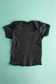 Flat lay mockup of a black basic cotton t-shirt for boys on a blue background Stock Photos