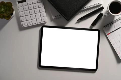 Flat lay, mockup digital tablet, calculator and office supplies on white table. Stock Photos