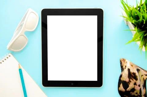 Flat lay mockup summer is coming concept. Tablet pc on a blue background with Stock Photos