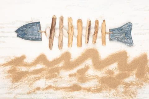 Flat lay nautical design with hand-crafted fish and sand Stock Photos