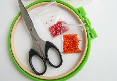 Flat lay needlework and embroidery accessories, scissors hoops and beads on Stock Photos