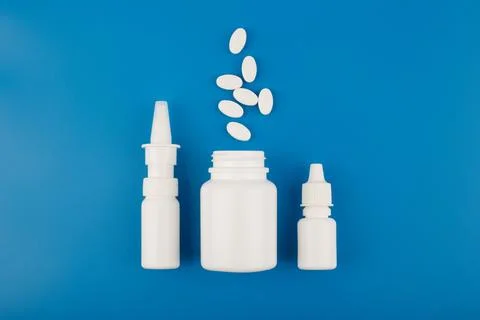 Flat lay with nose spray, medication bottle with spilled pills and eye drops in Stock Photos