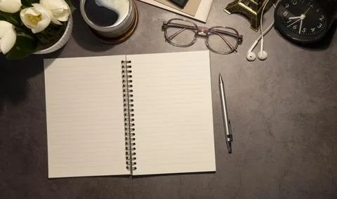 Flat lay notebook, coffee cup and potted plant on wood office desk. Stock Photos