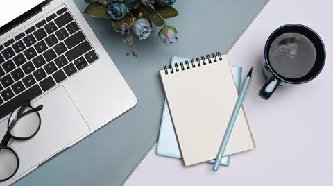 Flat lay notebook, computer laptop, glasses and coffee cup on white table. Foto stock