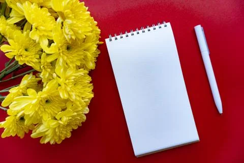 Flat lay of notebook, pen and flowers Stock Photos