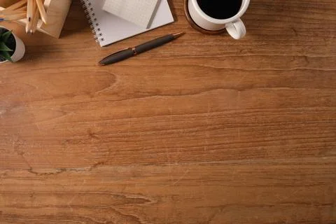 Flat lay notepad, cup of coffee, pen and pencil holder on wooden table. Top.. Stock Photos