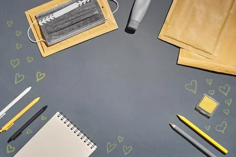 Flat lay notepad, pen, envelope, mask, tube and drawing harts on grey background Stock Photos