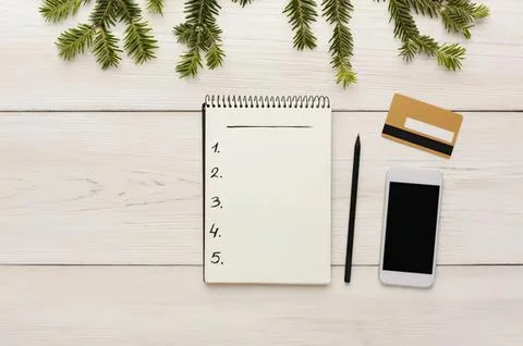 Flat lay of notepad pencil phone and credit card on white table Stock Photos