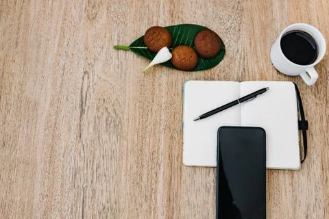 Flat lay with notepad, smartphone, cup of coffee and breakfast cookies 库存照片