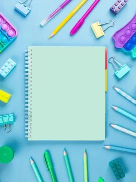 Flat lay office desk with a blank page of a notebook with a pen, pencils, wat Foto stock