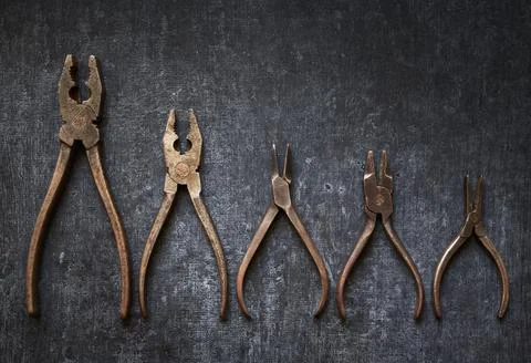 Flat lay Old hand tools, rusted pliers on gray background, close up Stock Photos
