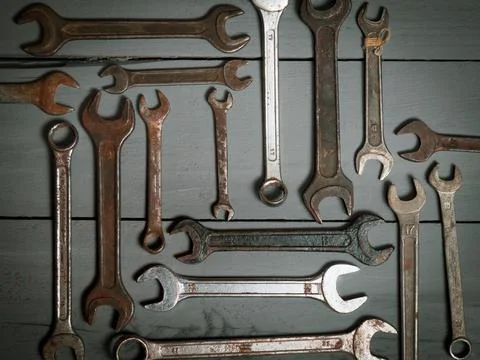 Flat lay old hand tools, wrench, rusty iron metal tools on gray wooden table Stock Photos