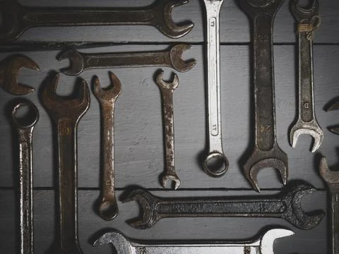 Flat lay old hand tools, wrench, rusty iron metal tools on gray wooden table Stock Photos