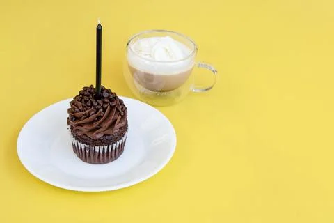 Flat lay of one cupcake with one candle and coffee with copy space Stock Photos