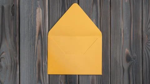 Flat lay of open empty yellow envelope on grey wooden table. Correspondence.. Foto stock