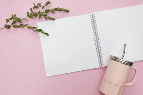 Flat lay of open notebook and cup with cap on a pink background Stock Photos