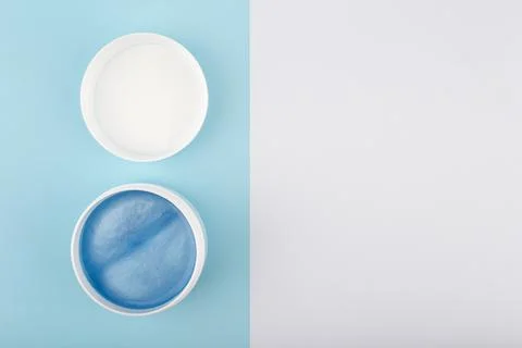 Flat lay with opened face mask with sea minerals on blue and white background Stock Photos