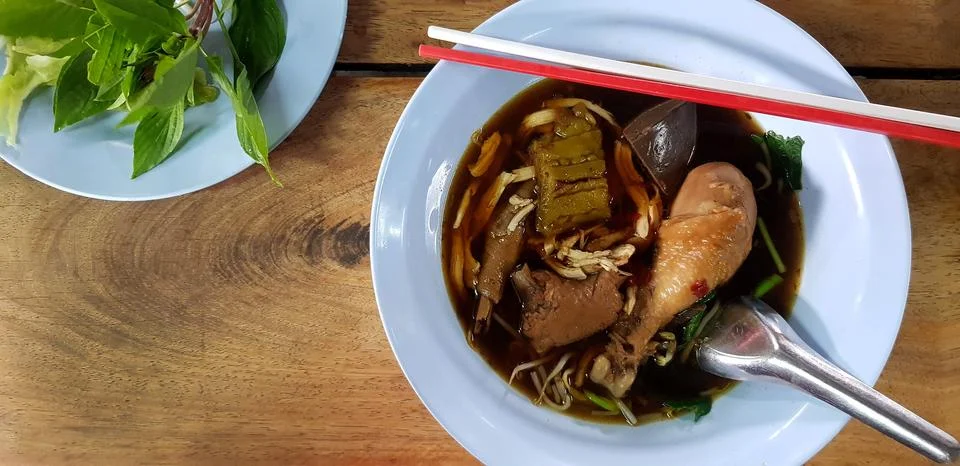 Flat lay or top view of hot chicken noodle with boiled bitter gourd. Stock Photos