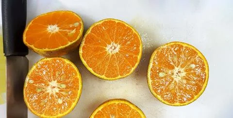 Flat lay or Top view of Group of Fresh sliced orange with knife on board Stock Photos