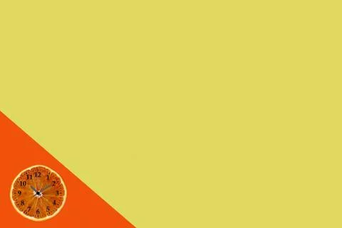 Flat lay of orange fruit slice with clock on yellow and orange paper backgrou Stock Photos