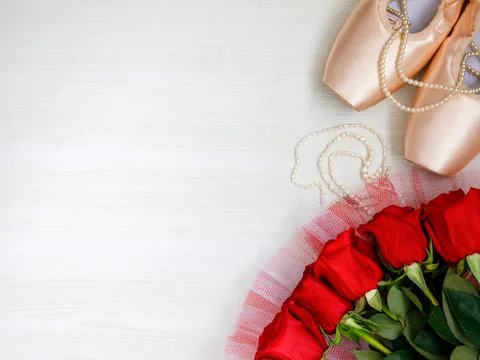 Flat lay pair of pink Pointe Shoes, pearl beads, red roses on white backgroun Stock Photos