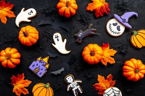 Flat lay pattern of halloween cookies and sweets. Party background Stock Photos