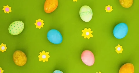 Flat lay pattern of multicolored Easter eggs, flowers on a green background Stock Footage 331505431