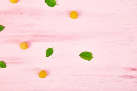 Flat lay pattern with yellow raspberries and mint leaves Stock Photos