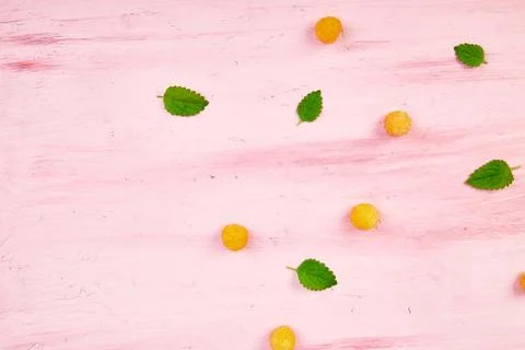 Flat lay pattern with yellow raspberries and mint leaves Stock Photos
