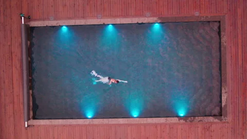 Flat lay perspective of female swimmer practicing crawl in turquoise outdoor Stock Footage 346768719
