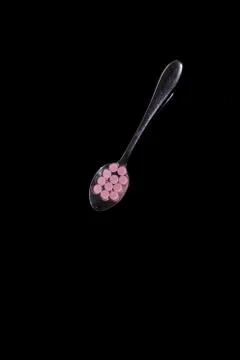 Flat lay of pile on spoon isolated black background Stock Photos