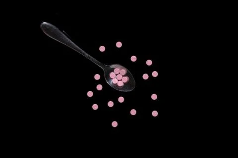 Flat lay of pile on spoon isolated black background Stock Photos